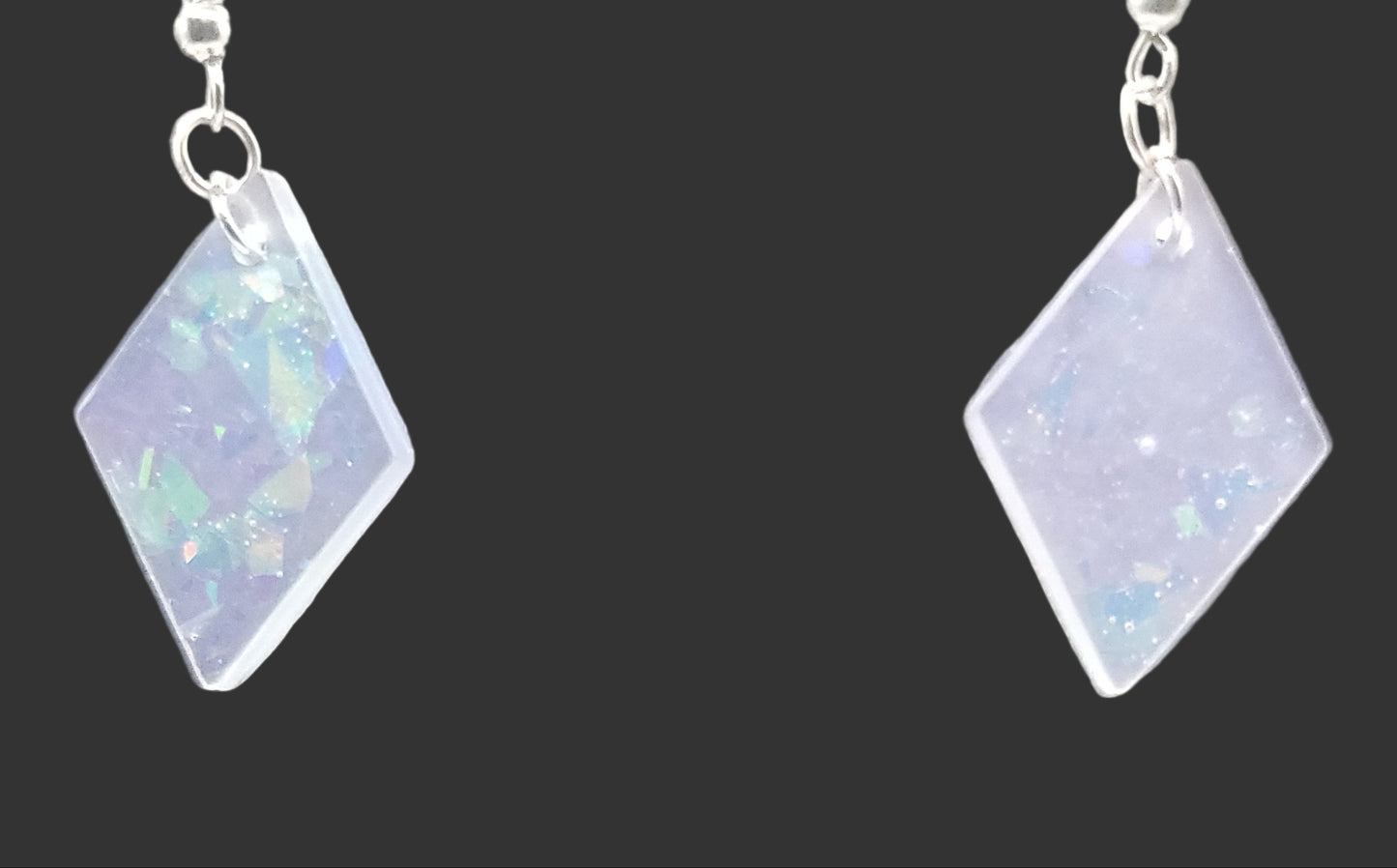 Diamond-shaped earrings with a reflective surface, opal on a gray background