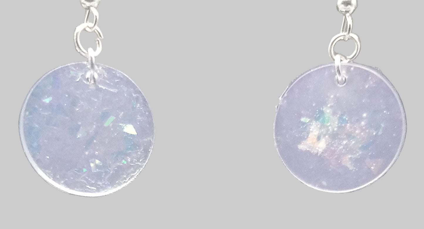 Earrings with round, iridescent disc pendants on a gray background