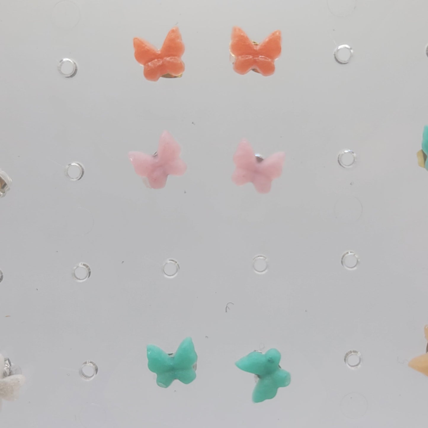Pegboard with colorful butterfly-shaped pegs on a light gray background