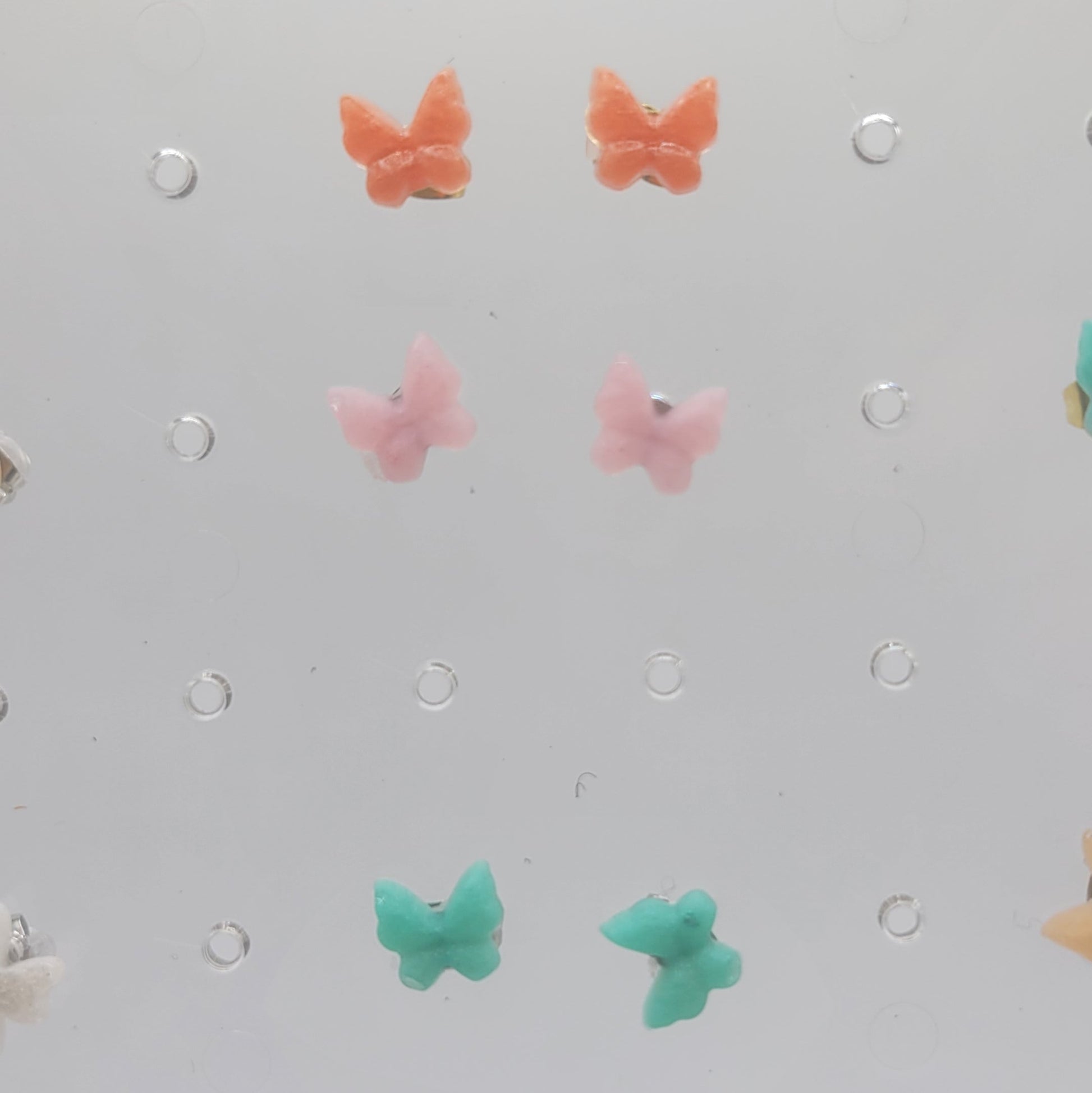 Pegboard with colorful butterfly-shaped pegs on a light gray background