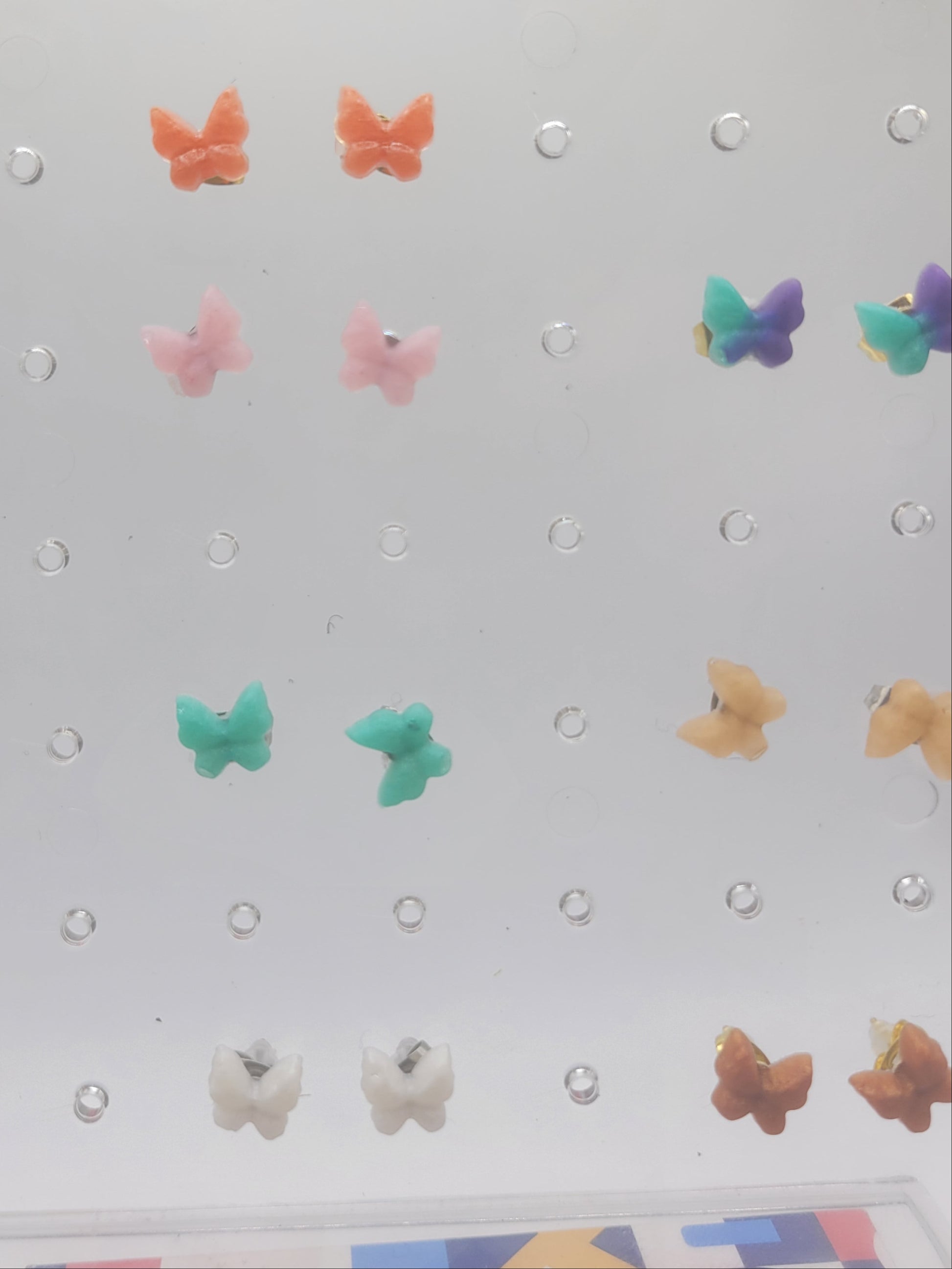 Pegboard with colorful butterfly-shaped pegs on a light gray background
