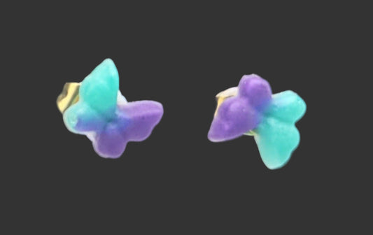 Butterfly-shaped earrings with a gradient of purple and blue on a black background.