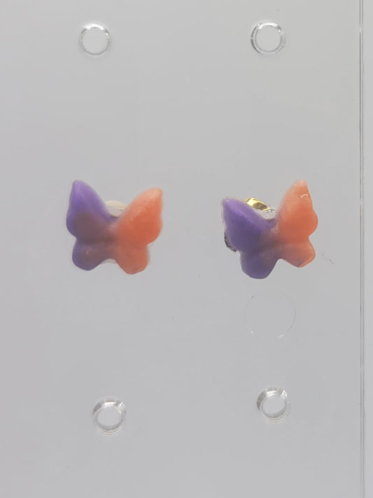 Set of colorful earrings on a clear display card.
