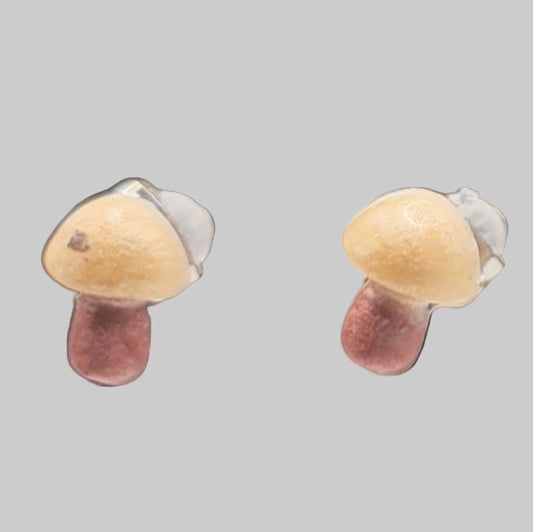 Mushroom-shaped earrings on a gray background