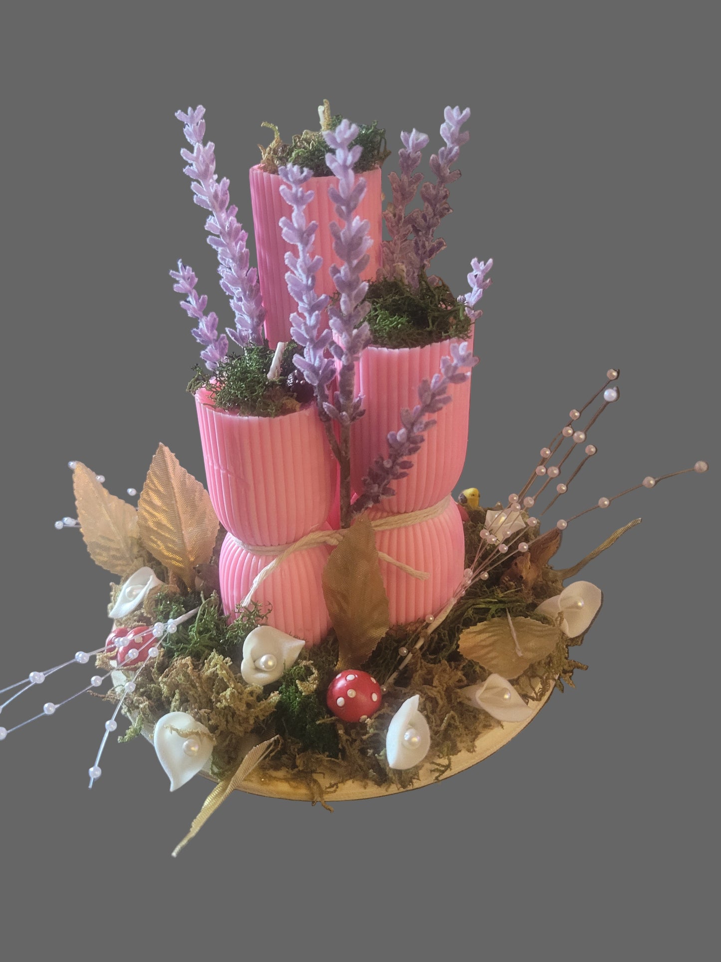 Decorative centerpiece with pink candles, flowers, and forest greenery. Scented and decorative