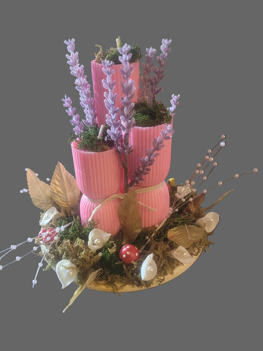 Decorative centerpiece with pink candles, flowers, and forest greenery. Scented and decorative