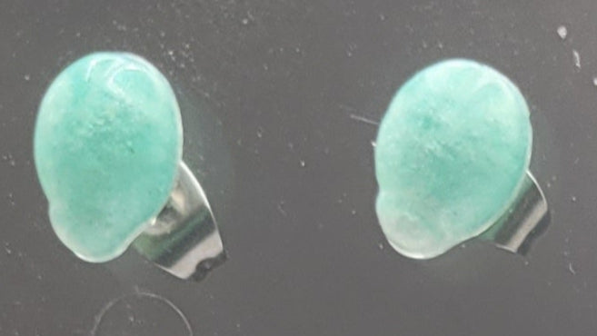 Pair of green stone earrings on a dark background