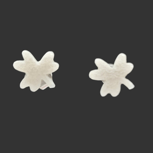 Pair of silver clover-shaped earrings on a black background